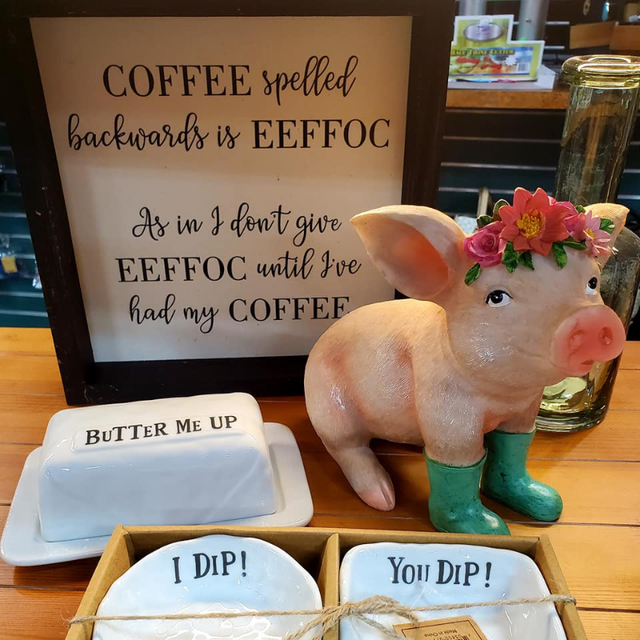  A collage of Signs, butter dish, dip plates, and a ceramic pig displayed on a table