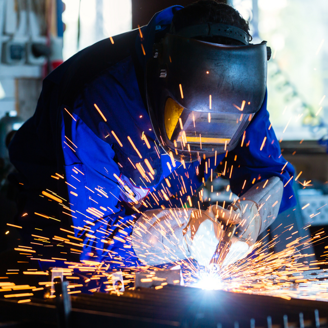 A welder wearing helmet welding something